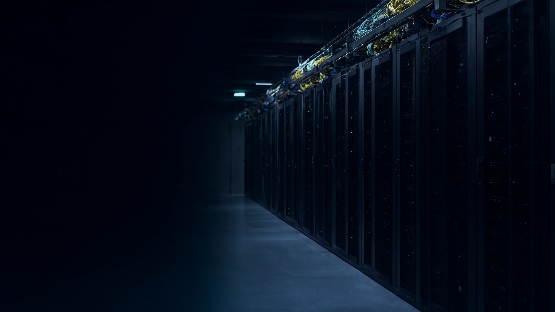 Hodnik data centra sa redovima rekova i snopovima optičkih kablova u plavičastom svetlu