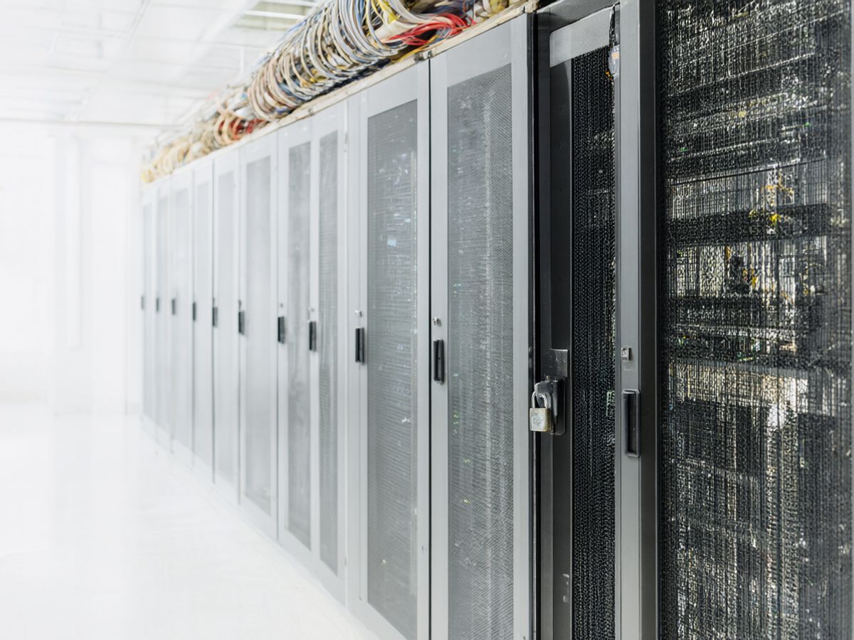 Zaključani rekovi u data centru iza mrežaste ograde sa katancem